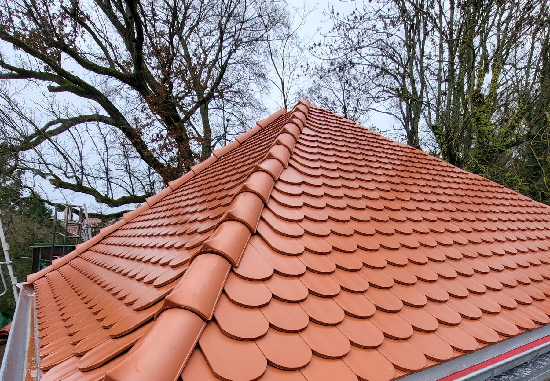 Toiture neuve en tuiles plates à écailles, arêtier et rive